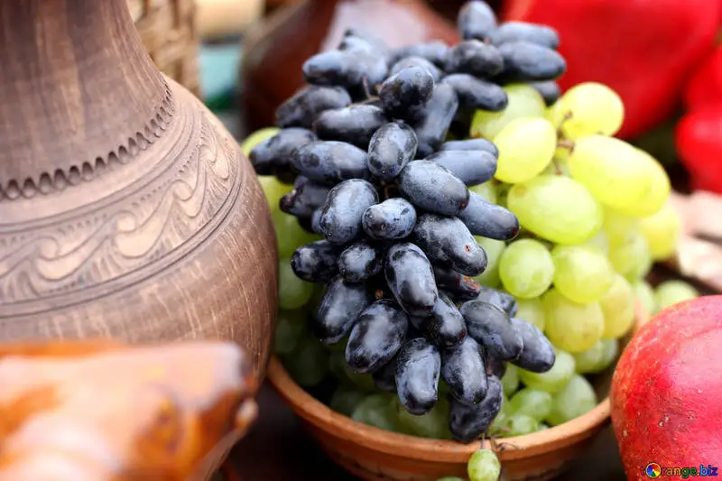 grapes in a bowl next to a traditonal Georgian pottery vessel