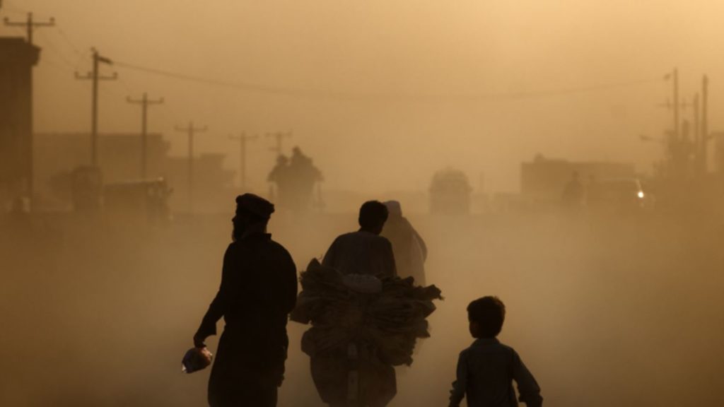 A few people walk and drive through thick smog in Kabul, Afghanistan